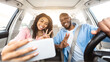 © Prostock-studio - Happy black couple driving car and taking selfie on smartphone
