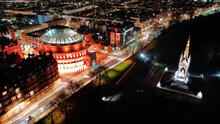 Aerial Drone Night Shot Of Illuminated Royal Albert Hall And Albert Memorial In Kensington Area, London, United Kingdom