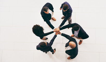 Poster - Teamwork turns the wheels of a business. High angle shot of a group of businesspeople joining their hands in solidarity.