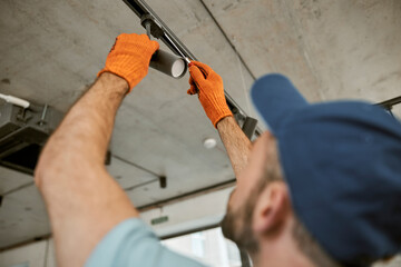 Canvas Print - Male hands in gloves repairing ceiling lamp