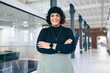 © Jacob Lund - Smiling businesswoman standing with her arms crossed