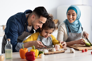 Wall Mural - Young Arab Father Showing How To Chop Mushrooms To His Little Daughter