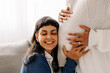 © (JLco) Julia Amaral - Happy young woman listening to her pregnant wife's belly