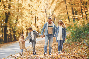 Wall Mural - Cheerful people. Happy family is in the park at autumn time together