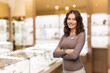 © Syda Productions - sale, shopping and business concept - happy female shop assistant with name tag and crossed arms over jewelry store background