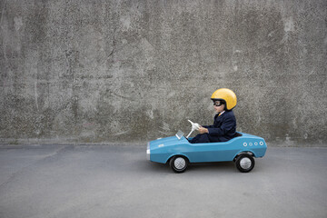 Canvas Print - Funny businessman driving retro pedal car outdoor