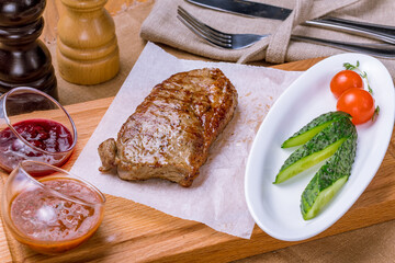 Sticker - juicy Striploin Steak on wooden board with sauces