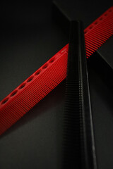 two flat combs from a professional hairdressing set lie on a black background