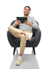 Sticker - people, technology and music concept - happy smiling man with headphones and tablet pc computer sitting in chair over white background