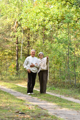 Sticker - Portrait of senior couple walking in autumn forest