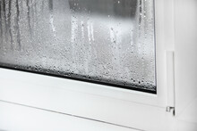 A Plastic Window With Condensation Of Water On The Glass. Double Glazed PVC Window. Concept: Defective Plastic Window With Condensation, Temperature Difference, Cooling, Humidity In The Room.