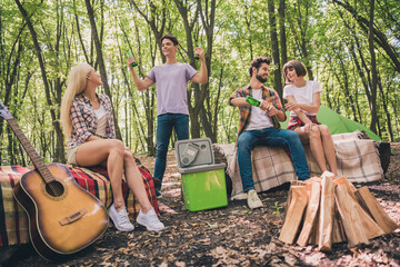 Sticker - Portrait of attractive cheerful four people resting in wild park sitting on cover spending free active time having fun outdoors