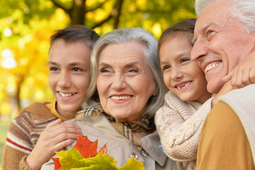 Wall Mural - Close up portrait of happy beautiful smiling family relaxing in autumn park