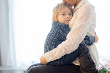 Canvas Print - Portrait of mother and child, hugging on a back lit white background