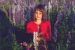 © ksenija1803z - young woman in red shirt with glasses working on laptop smiling in field of flowers in summer