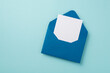 Top view photo of open blue envelope with paper sheet on isolated pastel blue background with empty space