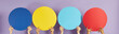 © Studio Romantic - People sharing opinions and sending messages. Group of anonymous young multiracial men and women holding round colourful blue, yellow and red blank mock up speech bubble banners on purple background