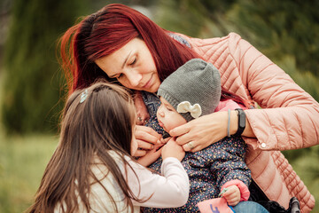 Wall Mural - Mother with two daughters playing in the park