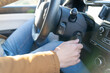 © pavelgulea - Young eastern man casually dressed with hands holding driving wheel, starting engine turning on ignition key in car on sunny day. No face, anonymous, travel, exam, lesson, learning, taxi driver