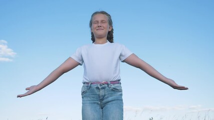 happy teenager raises his hands sky enjoying life nature.happy girl is dreaming against background o
