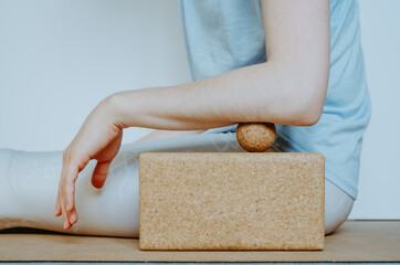 Forearm muscles myofascial release with small cork massage ball on cork block. Concept: self care practices at home, sustainable and eco friendly props