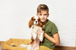 © Rodica - Happy child playing and embracing his puppy indoor. Teen boy with his puppy. Best friend and pet. Lovely dog