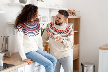 Poster - Happy young couple wearing warm sweaters at home