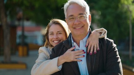 Wall Mural - Middle age couple couple smiling confident hugging each other at park