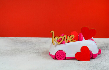 Wall Mural - valentines day background with copy space for text, festive car toy with love and wooden decorations shape heart, red greeting card