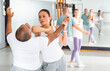 © JackF - Young Latina paired up with male partner in self defense training, practicing elbow hit in close combat