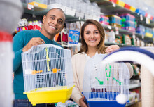 Couple Of Shoppers Looking For New Bird Cage In Pet Shop