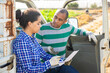 © JackF - Man and woman farmers signing papers and communicating near car on the farmer field