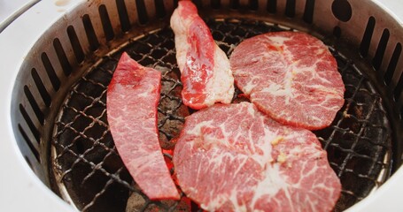 Wall Mural - Close up grilling roasting fresh juicy meat beef slices on charcoal grill, Japanese style yakiniku grill in restaurant	
