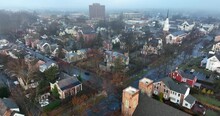 Aerial Establishing Shot Of Small Town In USA During Foggy Winter Rainy Morning.