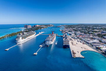 Wall Mural - The drone aerial view of cruise ships in the clear blue Caribbean ocean docked in the port of Nassau, Bahamas.