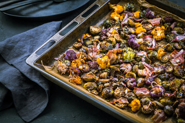 Wall Mural - Healthy food - Baked vegetables with Purple Brussels sprouts, broccoli, cauliflower and onions