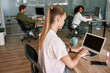 © Svitlana - Woman typing on laptop computer in spacious office