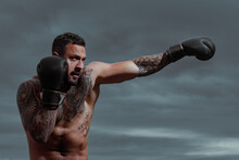 Portrait Of Tough Male Boxer Posing In Boxing Gloves. Professional Fighter Ready For Boxing Match. Sportsman Muay Thai Boxer Fighting. Boxer Punch.