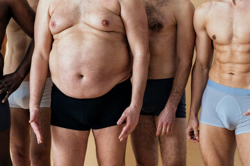 group of multiethnic men posing for a male edition body positive beauty set. Shirtless guys with different age, and body wearing boxers underwear