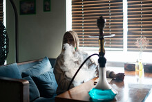 Young Girl Chilling In The Lounge And Smoking The Hookah