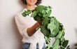 © Dina - Unrecognizable woman in white shirt holding green broccoli vegetables after grocery shopping for healthy food standing in the kitchen