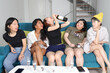 © oqba - Young Asian woman group talk gossip chat sing drink cheers party fun enjoy drunk tired rest funny faces expression on blue living room sofa