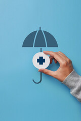 A medical cross and an umbrella over it. Symbol of health insurance and life protection