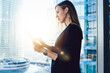 © BullRun - Confident professional female lawyer using app on touchpad connected to wireless internet making research in office,blonde business woman in formal wear browse via digital tablet near panoramic window