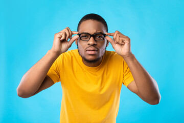 Wall Mural - Black Guy In Glasses Squinting Eyes Posing Over Blue Background