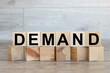 The word demand on stacked wooden cubes. Demand increase or rise in economy or business concept.