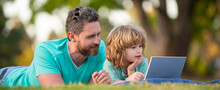 Father And Son School Boy With Laptop. Dad And Child Use Notebook Tablet Outdoors. Banner For Fathers Day Or Father And Son On Spring Background.