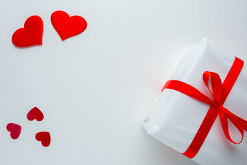 Valentine's Day background. A gift box with a red ribbon and hearts on a black background. Romantic concept