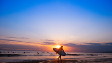 日本の綺麗な夕日と海岸の景色　サーフィンを楽しみむ人のシルエット