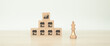 © Eakrin - Franchise or franchising, Close-up king chess and cube wooden block stack in pyramid with franchises business store icon for growth and products services or branch expansion bank loan.